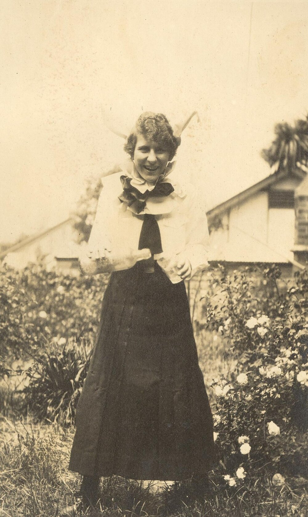 Photo of Winnie Woodmason in uniform but with bottle and glass, clown collar, c.1917