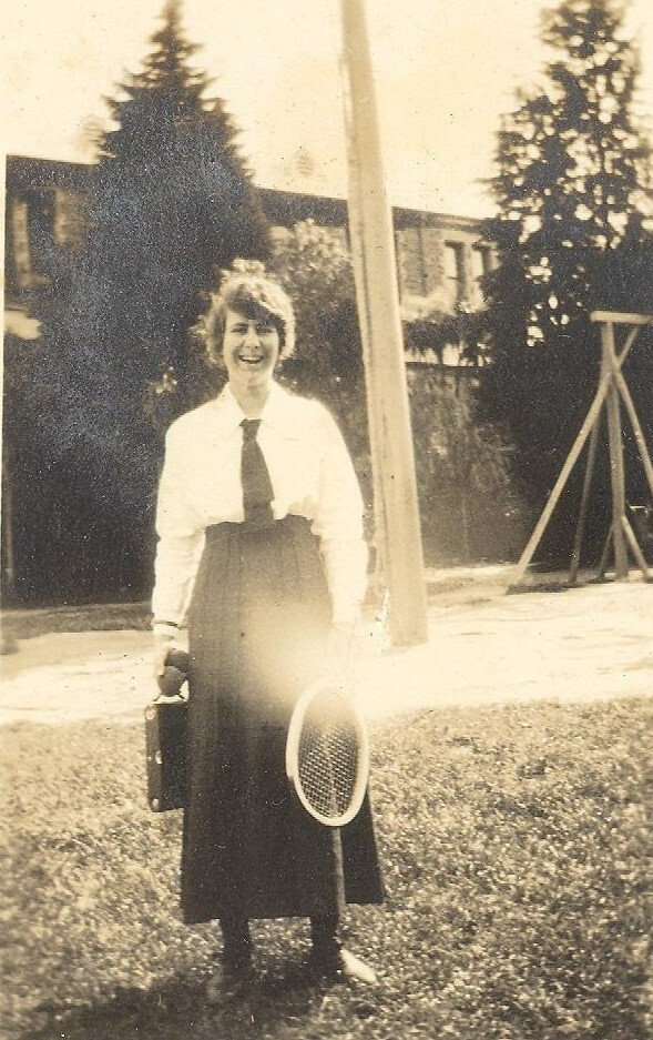 Photo of Winnie Woodmason at MLC holding valise and tennis racket, c.1917