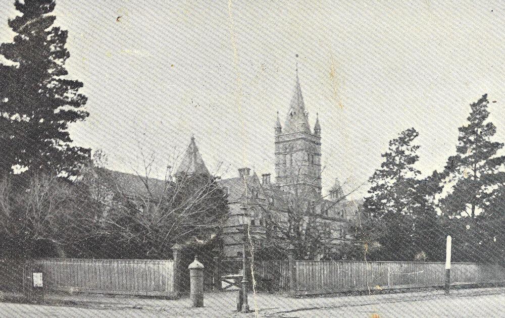 Photo of wooden fence around MLC from corner Barkers and Glenferrie, pre-1923, from postcard