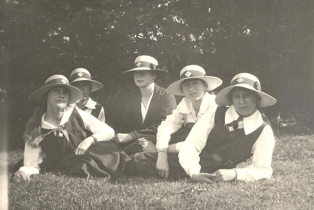 Photo of five students wearing MLC straw hats, lounging on lawn, labelled "Sports Day 1920"