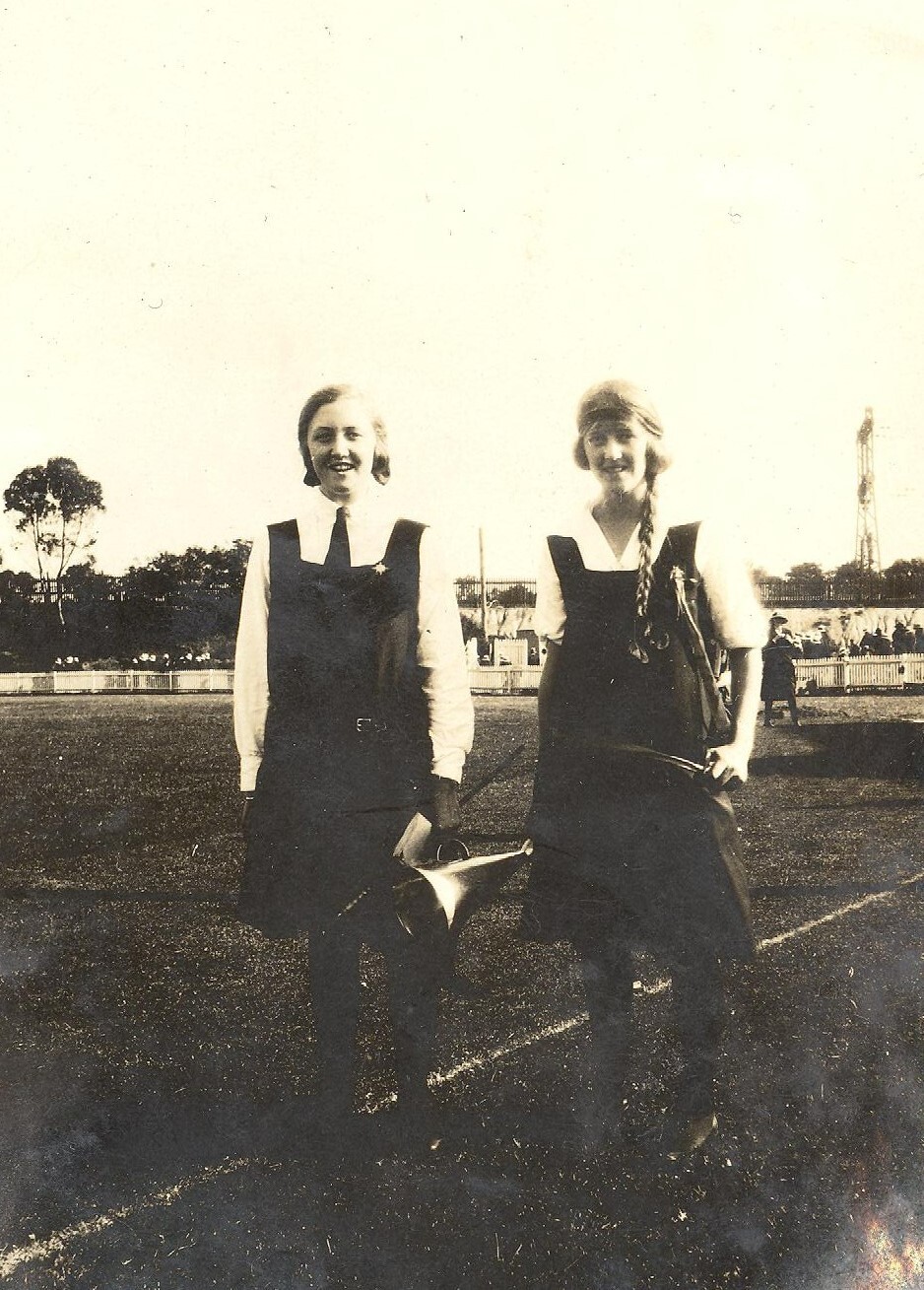 Photo of two students standing in sports field, c.1923