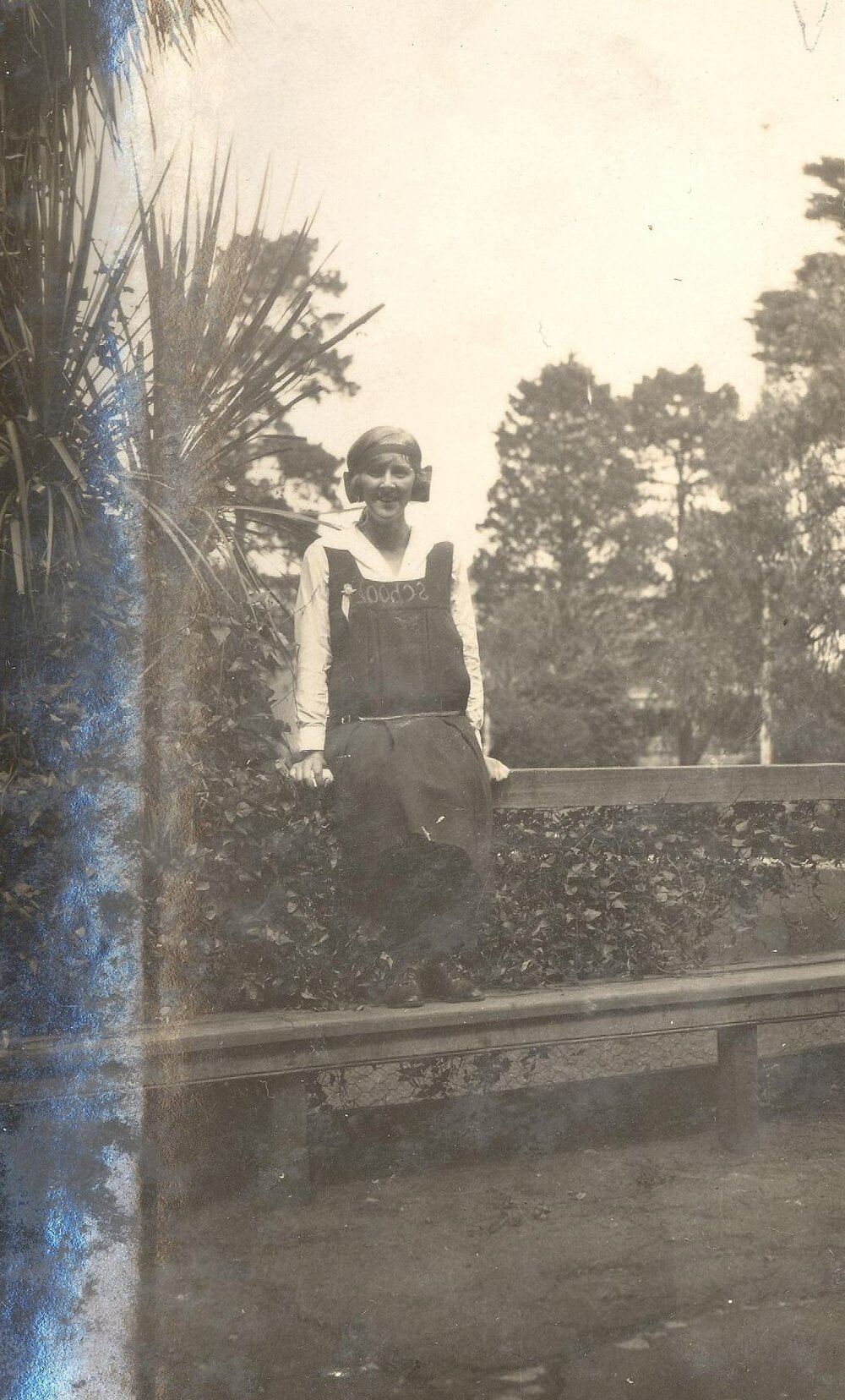 Photo of student on bench - probably front gardens - cc.1923