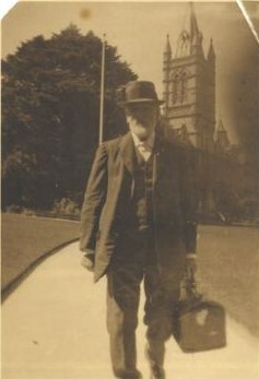 Rev. Dr. Fitchett walking along path from Residence towards Barker's Rd with bag, c.1924