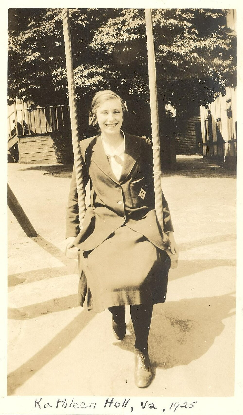 Photo of Kathleen Hull sitting on swing in quad, Form Va, 1925