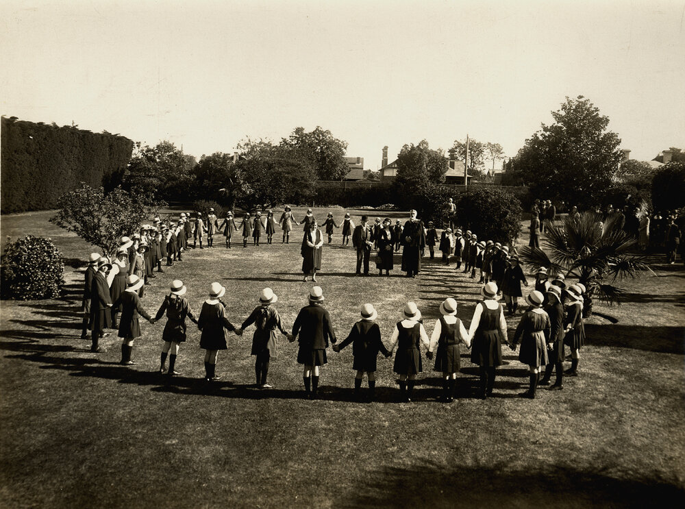 Photo of junior students holding hands in a circle at MLC Elsternwick, 1931