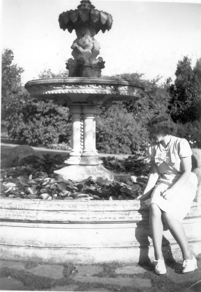 Photograph of Petera Campbell on fountain, wearing white dress, c.1941