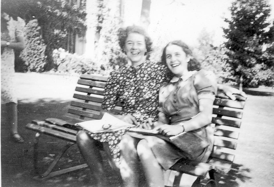 Photo of two Doreen Lancaster, Beryl Roediger in summer clothes seated on bench in front garden, c.1941