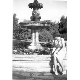 Photograph of Petera Campbell on fountain, wearing white dress, c.1941