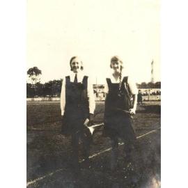 Photo of two students standing in sports field, c.1923