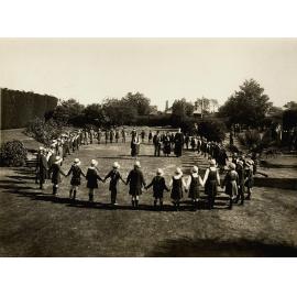 Photo of junior students holding hands in a circle at MLC Elsternwick, 1931