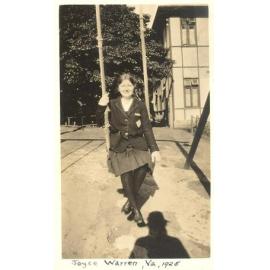 Photo of student Joyce Warren on swing, Hostel or North House in background, 1925